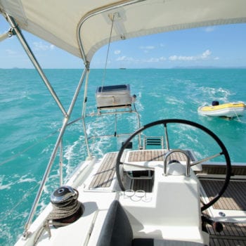 Whitsunday Escape sailing yacht Beneteau 411 stardboard helm looking back to dinghy & bbq