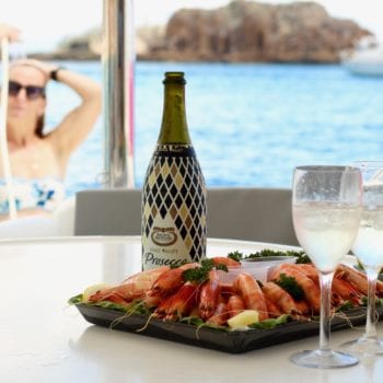 Platters with champagne and lady showering on the back of the boat
