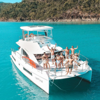 Group of friends standing on the deck of a Leopard 43.4 power catamaran in the Whitsundays