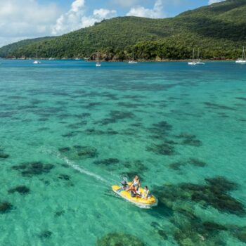 A tender motoring over a coral reef in the Whitsundays