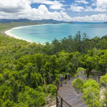 Two people enjoying the view at a lookout of a bay in the Whitsundays