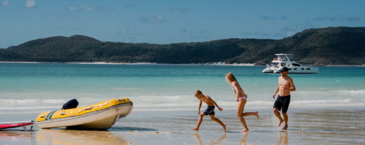 A Father and Mother chasing their son on Whitehaven beach.